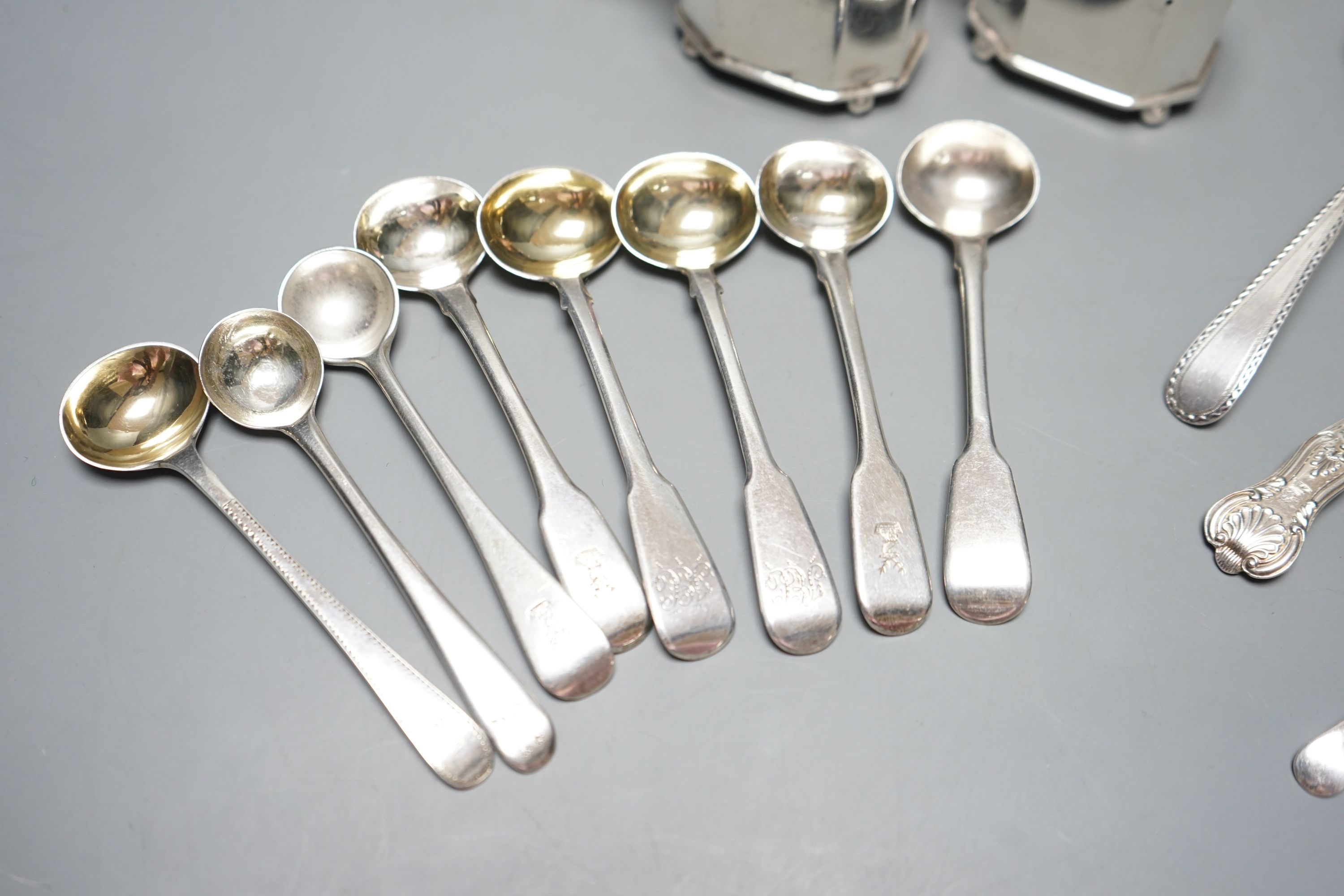 Seven assorted Georgian silver mustard ladles , a strainer, a pair of silver mustard pots and four spoons.